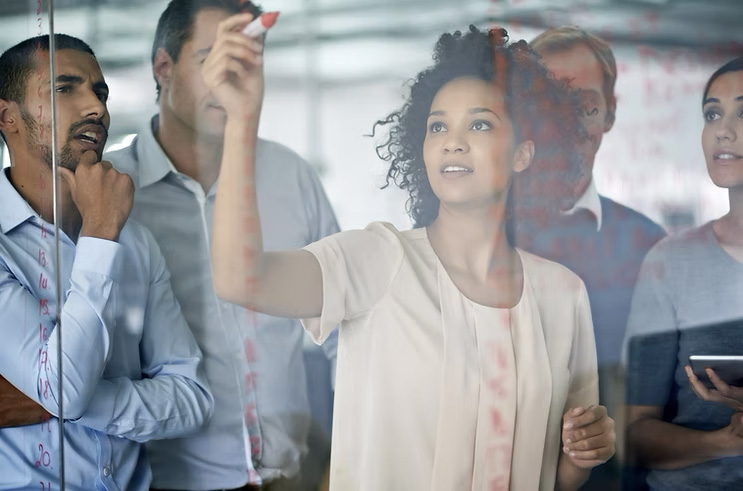 Réunion d'équipe avec brainstorming au tableau.
